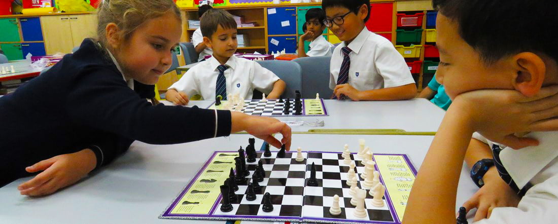 Photograph of enthralled children at GEMS wellington International School in Dubai playing chess