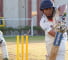 صورة تظهر شابًا يلعب الكريكيت ويتحرك نحو الكرة بمضرب هسهسة في المدرسة الثانوية الهندية في دبي