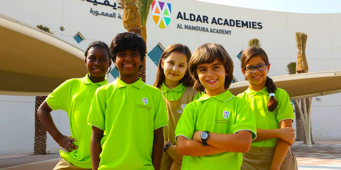 Foto von Kindern außerhalb der Gebäude der Al Mamoura Academy in Abu Dhabi
