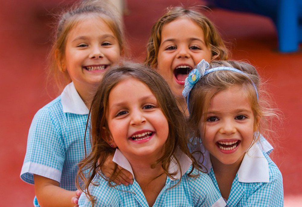صورة تظهر أطفال صغار يضحكون سعداء يرتدون الزي العسكري في المدرسة البريطانية الدولية في أبوظبي