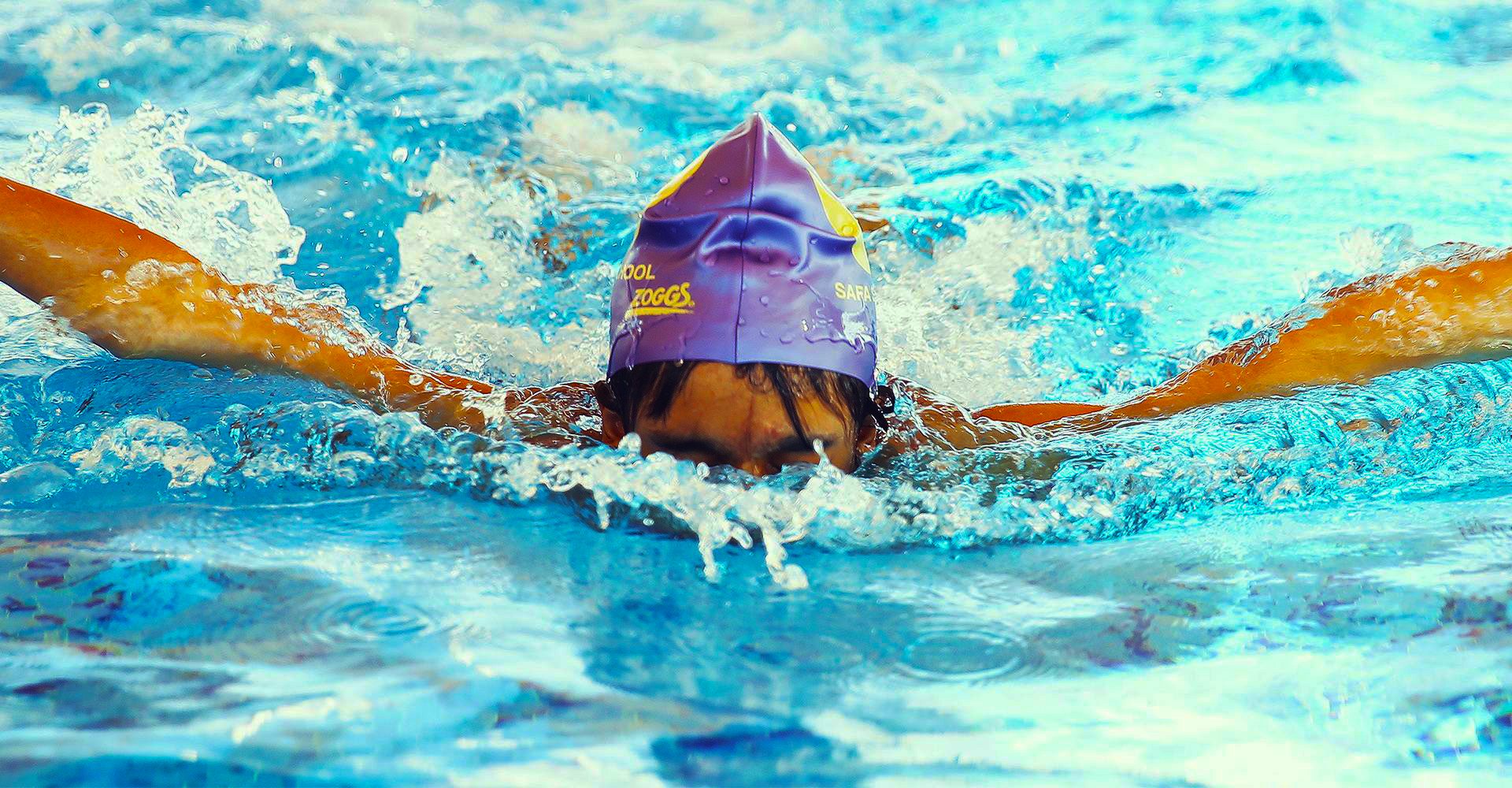 A photograph of a child competing in swimming at Safa Community School in Dubai