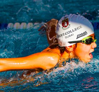 Foto eines Studenten, der im Wettkampfschwimmen am Kent College Dubai beschäftigt ist. Die Schule bietet spezielle Sportstipendien an, die maßgeschneiderte Mentoring-Programme beinhalten, die auf den Gaben der Schüler basieren.