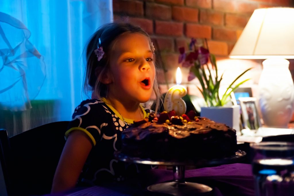 الفصل 3 اكتب تحديًا جديدًا يظهر فتاة عمرها ست سنوات تفجر شموع كعكة عيد ميلاد كبيرة من الشوكولاتة.