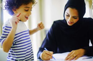 Foto eines Schülers, der Arabisch in einer Dubai-Schule lernt, die den Lehrer zeigt, der eine glückliche inspirierende Lektion durchführt