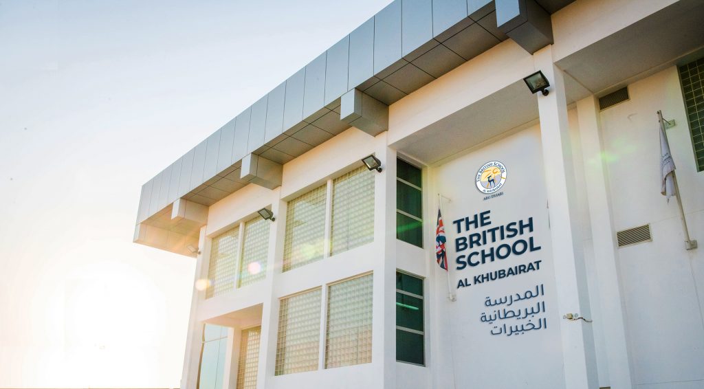 Foto der Gebäude und des Impressums der britischen Schule von Al Khubairat in Abu Dhabii mit erhobener britischer Flagge