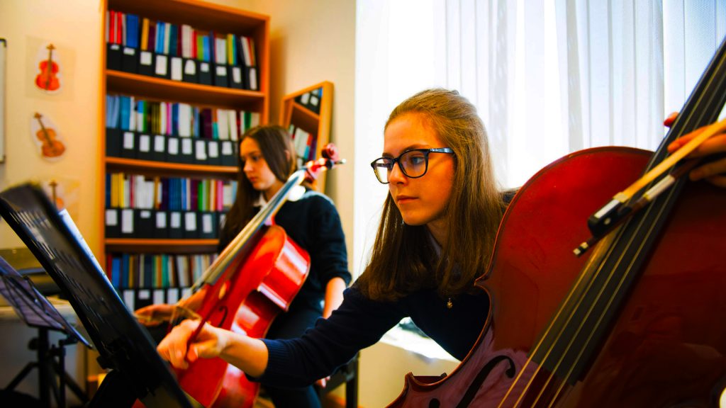 Studenten, die an der British School Al Khairat Musik am Cello und am Kontrabass üben