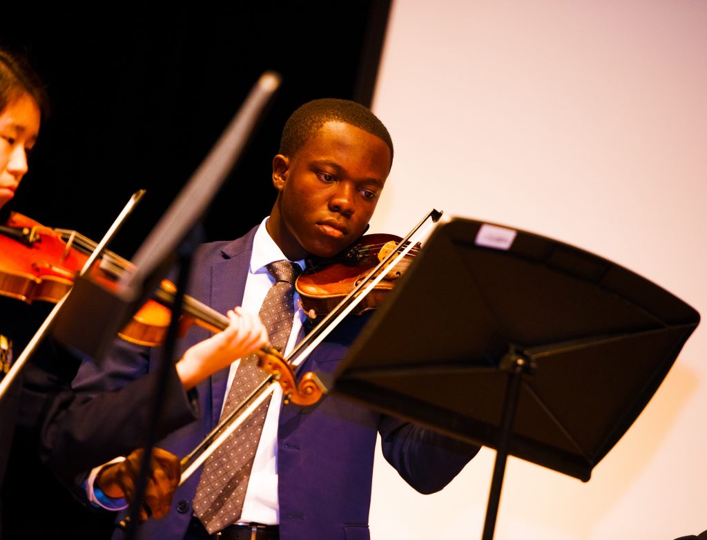 Estudiante tocando el violín como parte de la práctica orquestal en Brighton College Abu Dhabi
