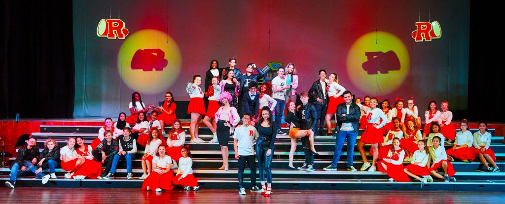 Musical production of Grease at Kings' School Al Barsha. Here we see children on stage performing the main theme song. 