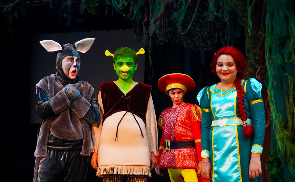 El teatro y las artes escénicas están integrados en el plan de estudios de Dubai English Speaking School DESS en Dubai. Aquí vemos a los niños interpretando una producción teatral completa de Shrek.