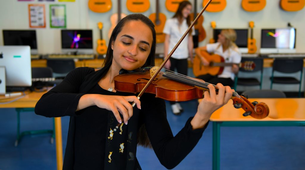 Actuación ad hoc de un violinista avanzado en GEMS Jumeirah College en Dubai. Un fuerte enfoque en las artes creativas y la expresión de los estudiantes es parte integral de la vida cultural en la escuela de Nivel 1.