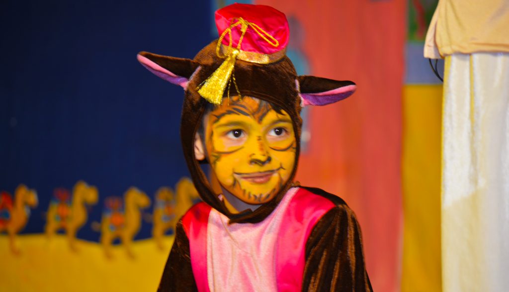 طفل يرتدي زي الإنتاج المسرحي الموسيقي في مدرسة أمريكا الشمالية الدولية في دبي