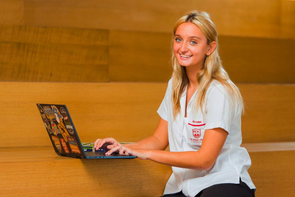 Review of the English College Dubai with a photograph highlighting the happy school dynamics and a Sixth Form student engaged in study for A' Levels