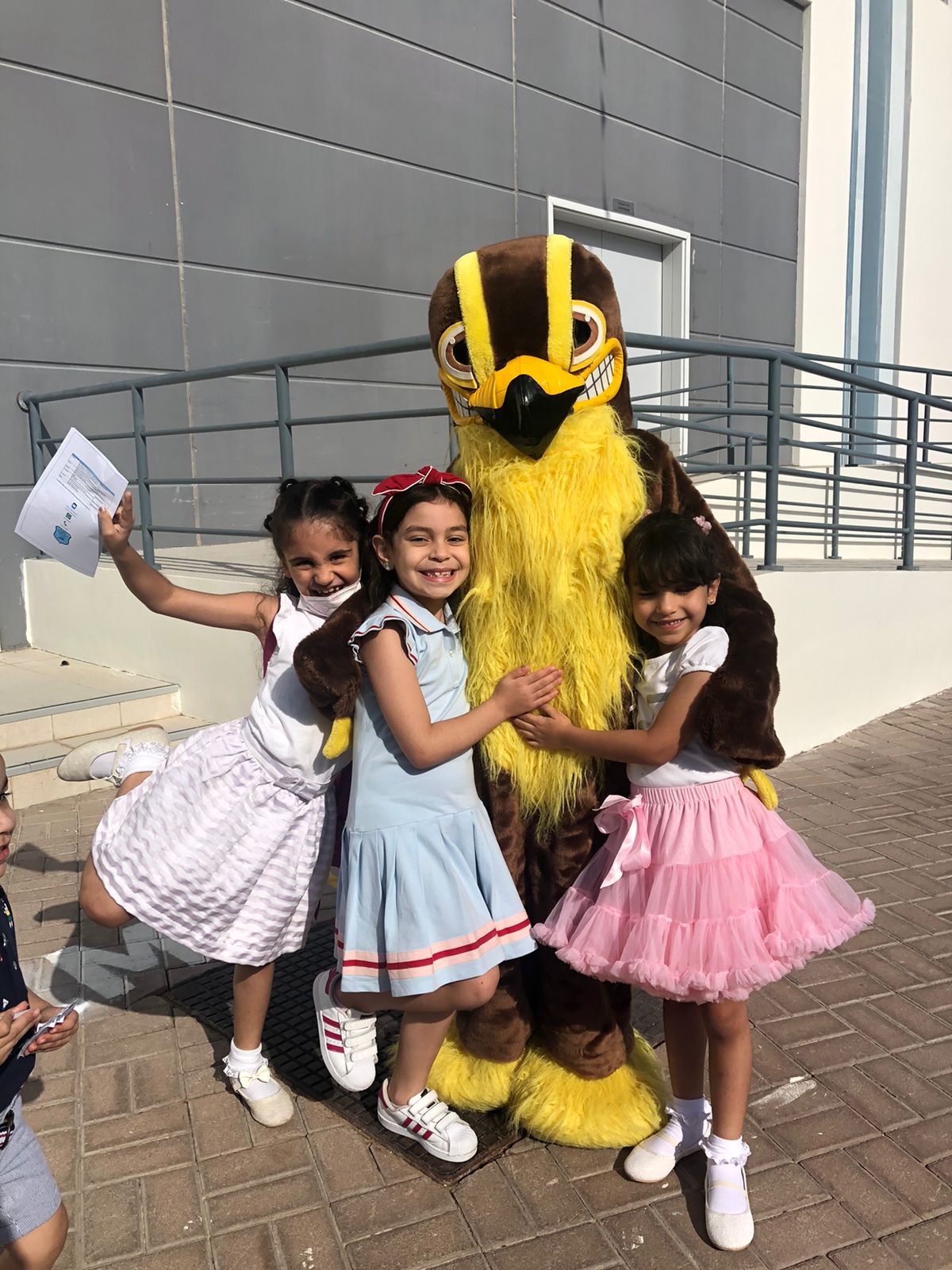 Photographs of the Festival of Schools held at GEMS FirstPoint school in Dubai. Here children hug one of the walk-around characters. 