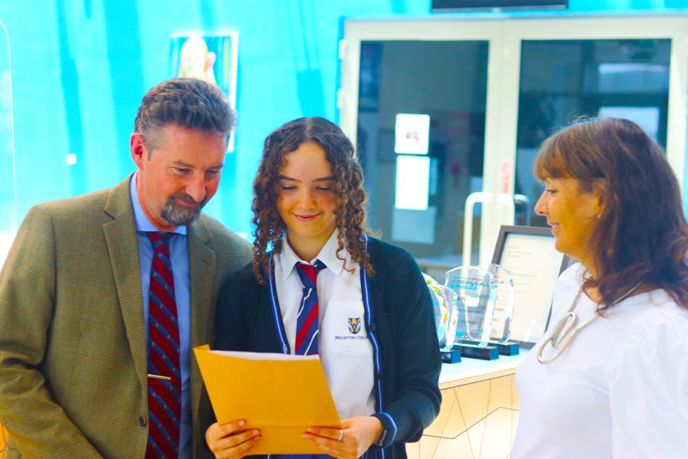 Photograph of GCSE Results Day 2022 at Brighton College Alain - a day when parents, teachers and students joined together to feel so proud of each other any their school. Brighton College Al Ain student Lucy Evans pictured being presented with her certrificate.