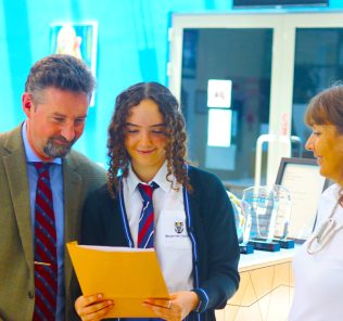 Photograph of GCSE Results Day 2022 at Brighton College Alain - a day when parents, teachers and students joined together to feel so proud of each other any their school. Brighton College Al Ain student Lucy Evans pictured being presented with her certrificate.